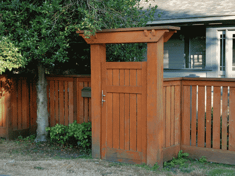 Painted arbor gate at the entry of a cute house