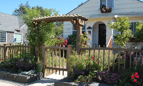 Wood arbor with gate provides a nice entryway to this garden