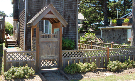 Wood arbor provides a nice entryway as part of the fence and has a gate.